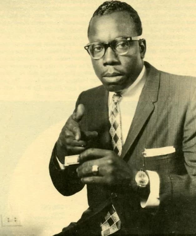 Slim Harpo seated with harmonica in a portrait image